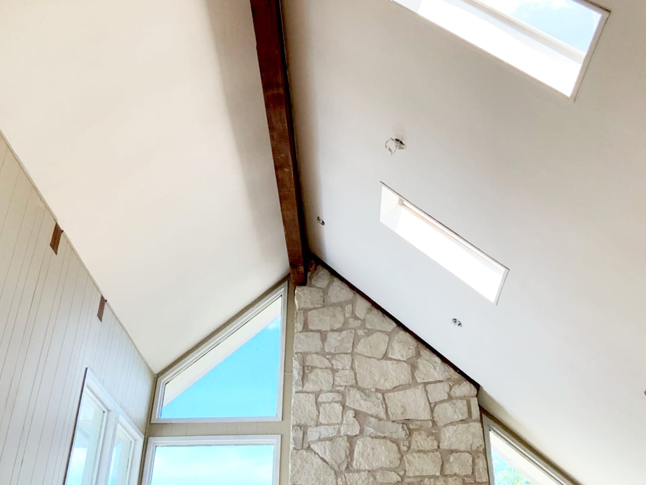 vaulted living room ceiling with beam and smooth texture