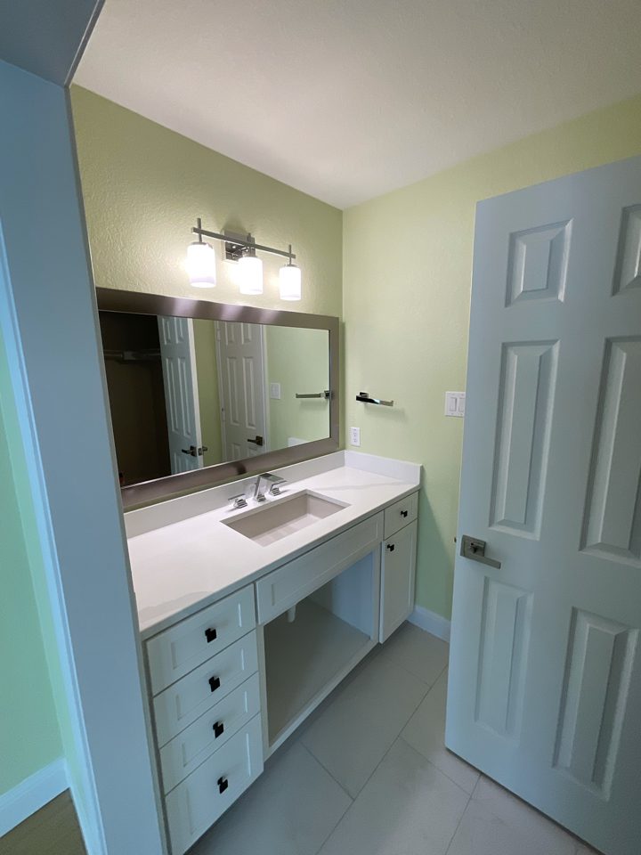light green bathroom walls with white painted vanity cabinet