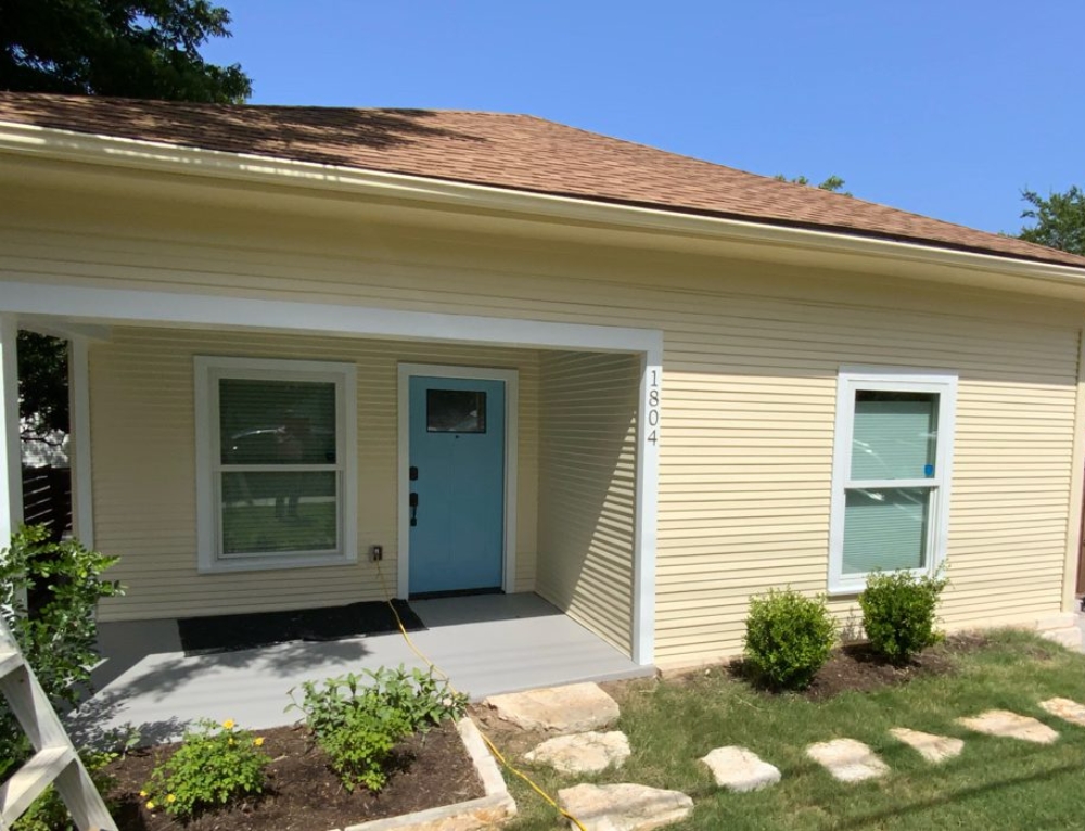 Green House Exterior with Dark Trim – SurePRO Painting
