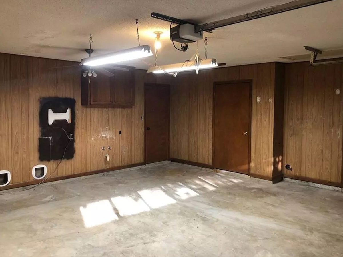 BEFORE dated garage with concrete floor and wood panel walls